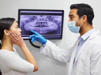 Dentist discussing xray of wisdom teeth with patient