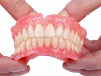 Dentist holding a set of dentures- Hamilton