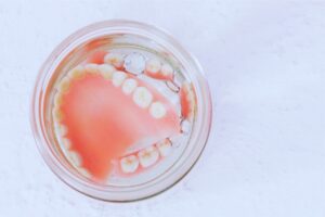 Dentures soaking in a glass, dentures and sleep